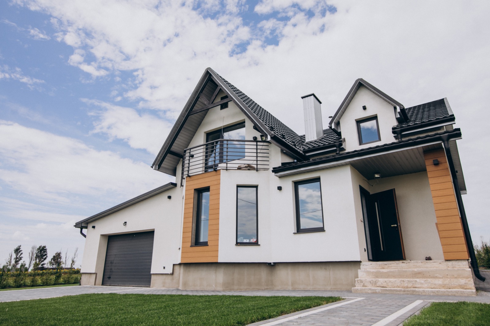 Family home with pitched roof, front steps, and green lawn